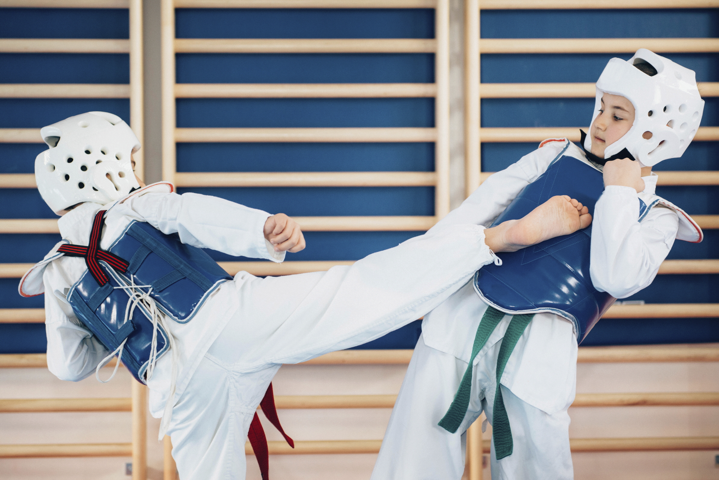 Two kids sparing in taekwondo class.